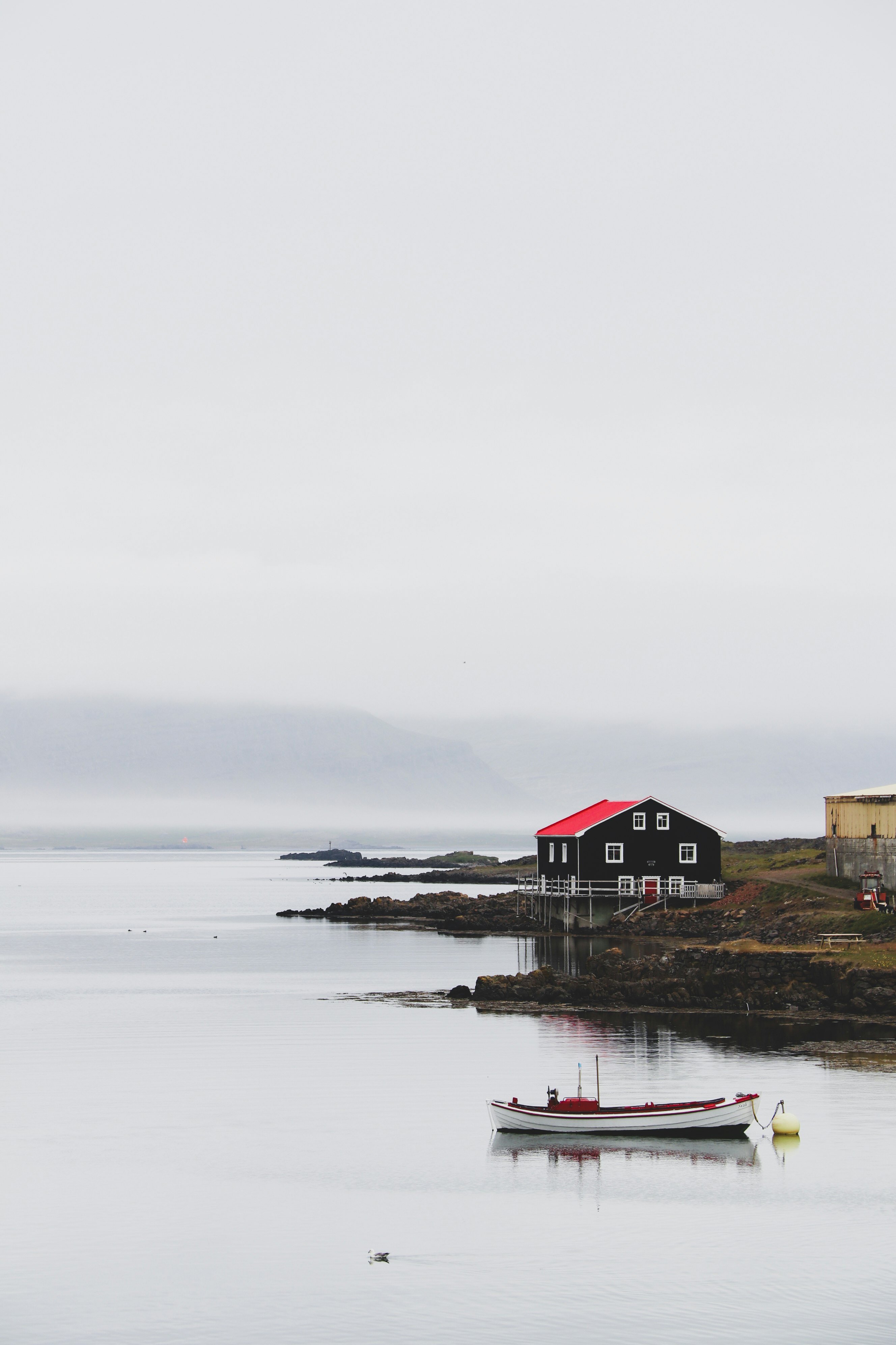 brown wooden house near body of water during daytime